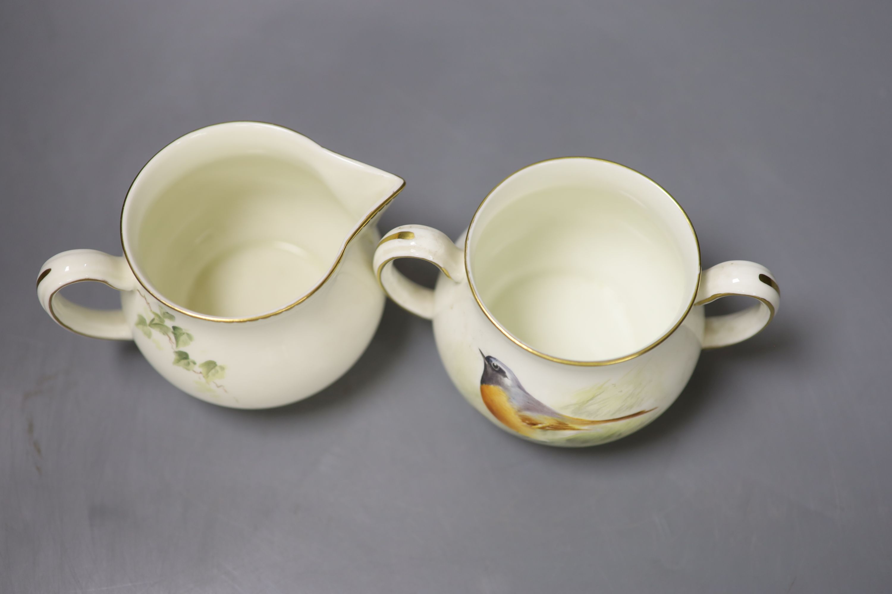 A Royal Worcester sugar bowl painted with a Redstart and cover and a cream jug painted with a Wren by E. Townsend, signed black mark